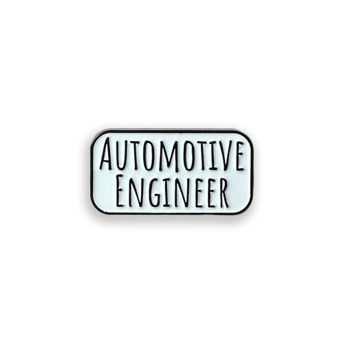 Enamel pin with the word automotive engineer on it, on a white background