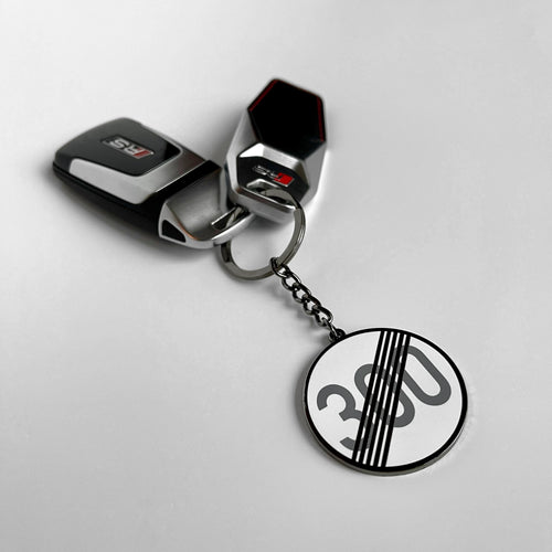Autobahn derestricted sign hard enamel keyring — angled view